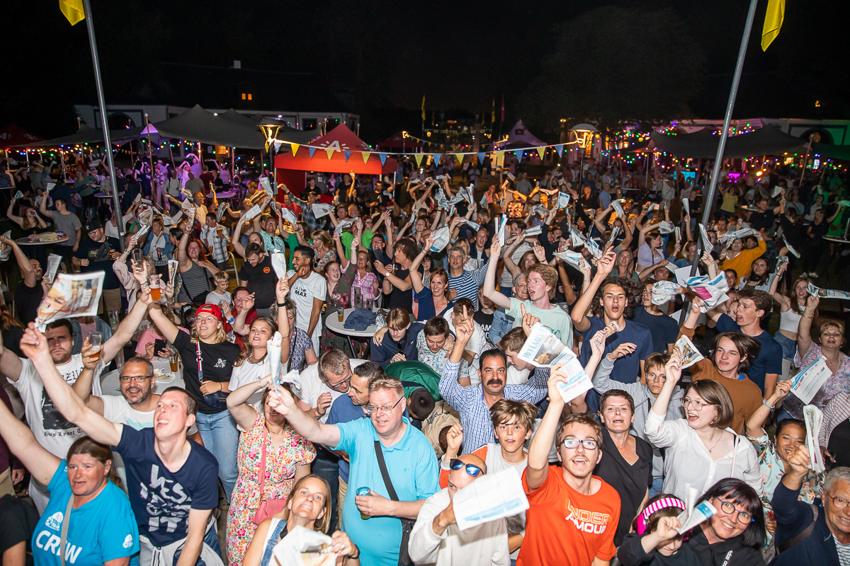 Gezellige familiesfeer in het Bouckenborghpark tijdens Merksem Feest en Zingt, met spelende kinderen, optredens en meezingende bezoekers